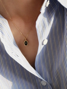 Detailed view of an oval MJ letter pendant on a fine gold-plated S925 silver chain