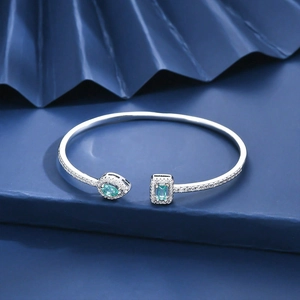 Detailed shot of silver adjustable cuff bracelet featuring emerald stones and pavé crystals