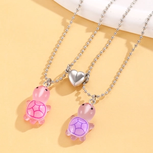 Close-up of magnetic heart clasp with pink and purple turtle pendants on bead chains