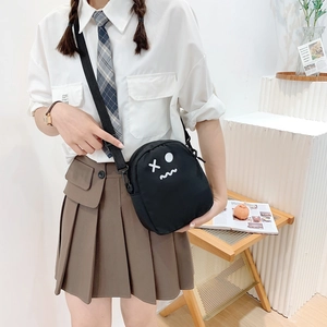 Détail du petit sac bandoulière en toile noire avec broderie cartoon et sangle réglable