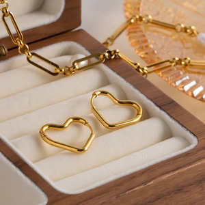 Detail of 18K gold-plated heart hoop earrings in a wooden jewelry box velvet slot