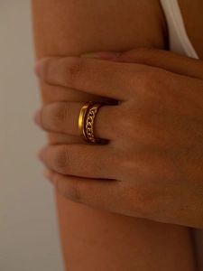 Detailed view of a layered gold titanium ring featuring curb chain texture and smooth band