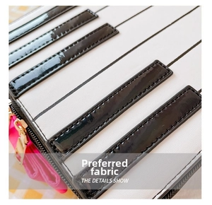 Macro shot of piano key bag details showing black patent leather and white textured leather