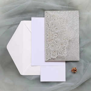 Detailed set of silver glitter laser-cut wedding invitation with blank inserts and envelope