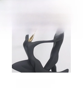 Detail of modern abstract dance sculpture in matte black with golden metallic accents