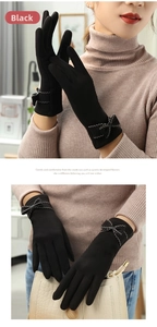 Detail of black thermal gloves featuring an elegant bow and zigzag decorative stitching