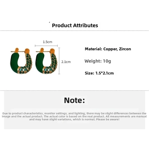 Detail view of U-shaped earrings with green enamel, zircon inlay, and size measurements