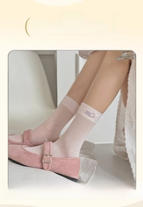 Dettaglio di calzini a rete rosa con fiocco e scarpe Mary Jane in stile balletcore