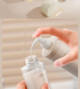 Detailed shot showing the process of filling a 35ml travel shower gel bottle