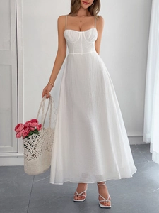 Full length view of a white A-line maxi dress with spaghetti straps and structural bodice details