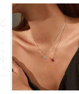 Gros plan d'un pendentif en cristal bleu clair taille octogone sur chaîne en argent