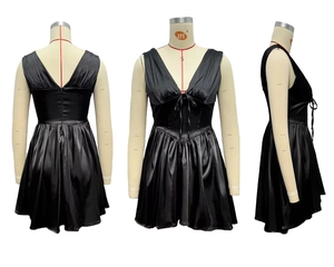 Detail of black satin mini dress showing deep V-neck, waist bow, and pleated hem