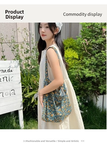 Detail of blue floral canvas tote bag with yellow flowers worn by a model in a garden