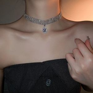 Détail macro d'un collier choker scintillant avec pendentif géométrique en goutte ovale