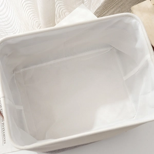 Minimalist beige cotton linen storage basket with thick EVA padding and brown faux leather handles