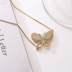 Detailed macro view of gold plated butterfly pendant with micro-paved cubic zirconia stones
