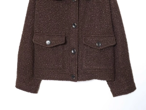 Détail de la veste sherpa marron foncé avec poches à rabat et fermeture à boutons