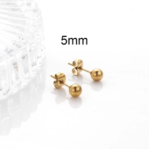 Close-up of 5mm golden stainless steel ball stud earrings with decorative glass