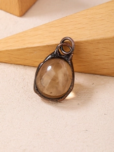 Detailed view of raw smoky quartz crystal pendant wrapped in vintage bronze wire