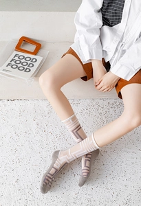 Detailed macro view of sheer crew socks with asymmetric beige and taupe geometric patterns