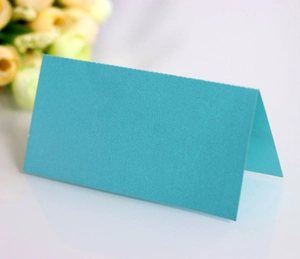 Close-up of a teal blue butterfly-cut folding table card on a white background
