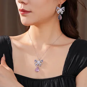 Elegant silver necklace and earrings set with purple zircon teardrops and bow designs
