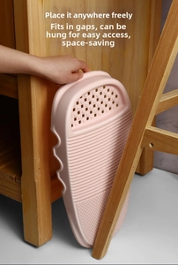 Pink plastic washboard stored in a narrow gap showing its slim space-saving design