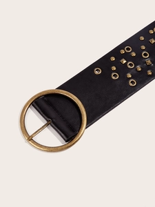 Detail of vintage black PU leather belt with gold round buckle and decorative studs