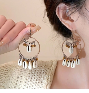Detail shot of bohemian shell bead tassel earrings with vintage bronze rings on a model