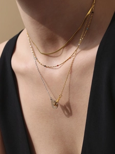 Détails de colliers superposés en or avec pendentif menottes et perles colorées
