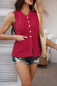 Detail of rose red sleeveless vest featuring V-neckline and white button-down front