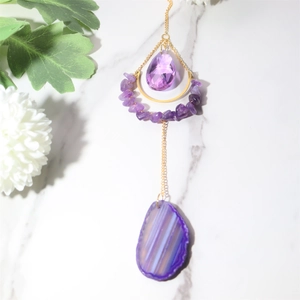 Macro detail of natural agate slice and purple crystal suncatcher with gold moon frame