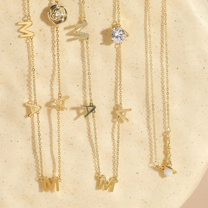 Detailed macro of gold letter necklaces with mama pendant and sparkling heart charms