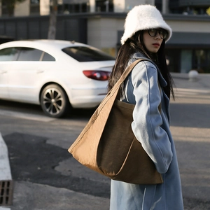 Minimalist large brown nylon tote bag for women shown in a stylish outdoor street style