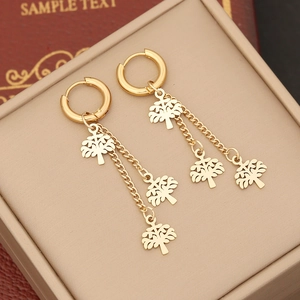 Detail of gold layered tree pendant tassel earrings on a premium jewelry box
