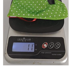 Detailed view showing the lightweight 11g Christmas stocking on a precision digital scale