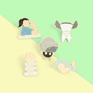 Detail view of five enamel gym badges featuring strong arms and kittens on green background