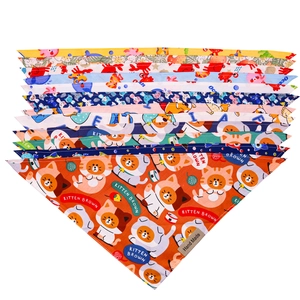 Detail of handmade cotton pet bandanas with diverse cartoon prints and leather labels