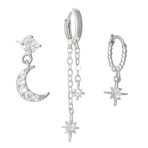 Macro detail of silver moon and star earrings set with sparkling zircon stones