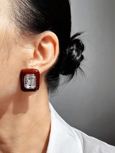 Close-up of vintage red enamel square stud earrings with clear rectangular crystal detail