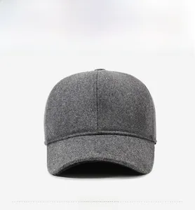 Close-up of a grey winter baseball cap featuring a metal shield emblem and thick wool texture