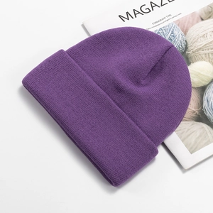 Detail of purple knitted wool beanie texture on a white background with a magazine