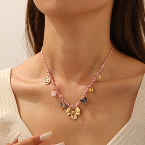 Bohemian braided cord necklace featuring golden bow and blue butterfly charms on model