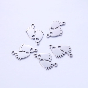 Detailed view of five silver baby footprint pendants in polished stainless steel