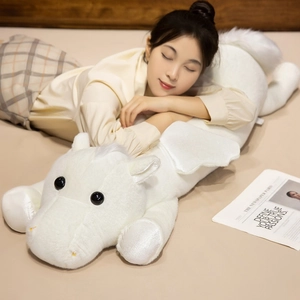 Large plush white unicorn toy with soft wings, used as a cozy pillow for home decor