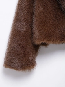 Close-up of luxurious brown faux fur texture and dense fibers on a cropped winter coat