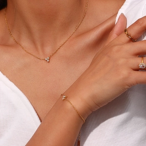 Close-up of gold plated stainless steel bracelet and ring set with white zircon stones