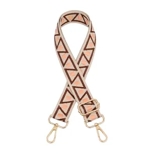 Detail of adjustable woven bag strap with geometric patterns and gold lobster clasps