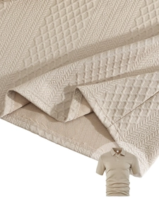 Detail shot of men's polo shirt featuring 3D diamond and herringbone knit texture in beige