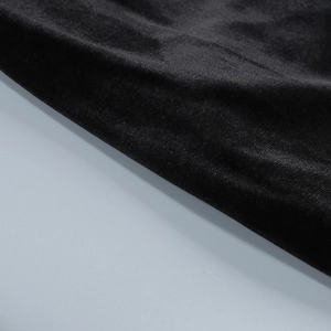 Close-up of premium black velvet fabric showing rich texture and soft folds on the gown